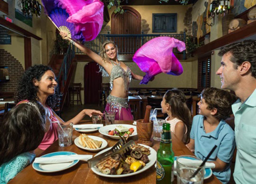 Family watching a belly dancer at a table