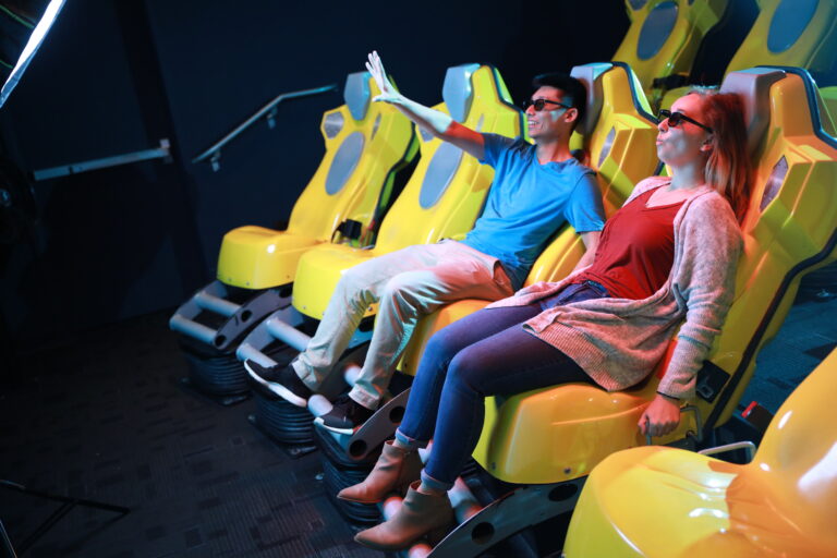 Two people on a virtual reality ride.
